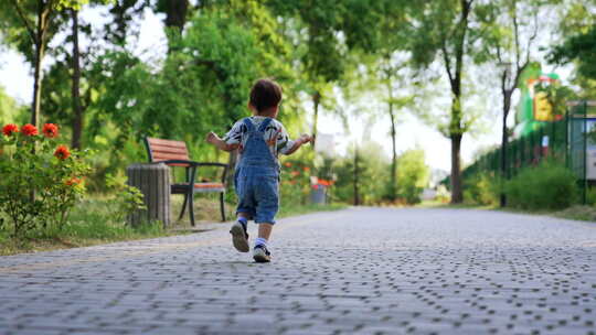 小男孩在户外跑步。孩子在外面的公园里跑步