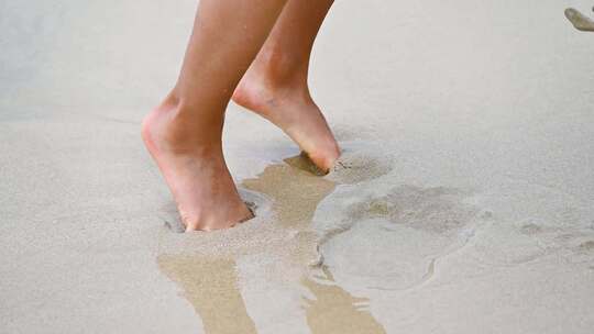 海边沙滩上海浪浪花与儿童脚丫慢动作