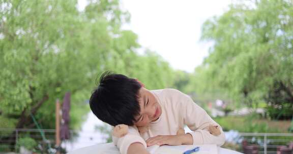 小孩在户外学习写作业压力苦恼抓耳挠腮