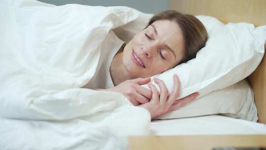 和平宁静的年轻女子睡在舒适舒适的白色床上