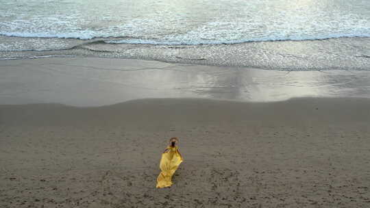 海滩上穿着黄色连衣裙的女人