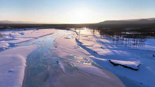 夕阳下内蒙古北方不冻河平静水面雪雾袅袅