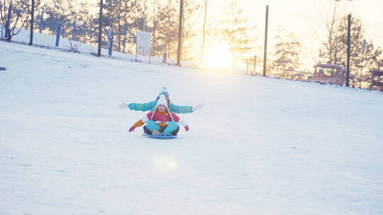妈妈和女儿在雪地里开心的滑雪