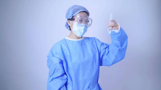 穿着一次性手术服的医生手持检验样品