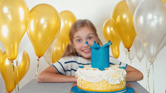 女孩看着她的生日蛋糕