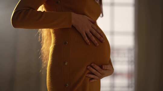 女人在家里抚摸怀孕的肚子未来的母亲关心婴