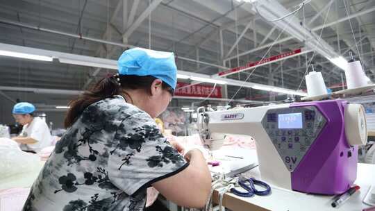 工厂女工操作缝纫机工作画面