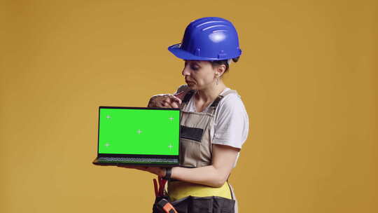 女人拿着带绿屏的笔记本电脑