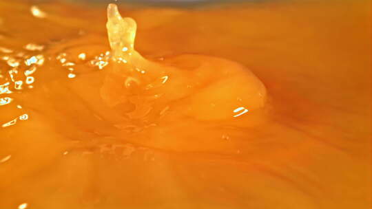 一片新鲜的橙子掉进橙汁里溅起水花