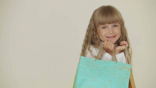 快乐的小女孩拿着彩色的纸袋