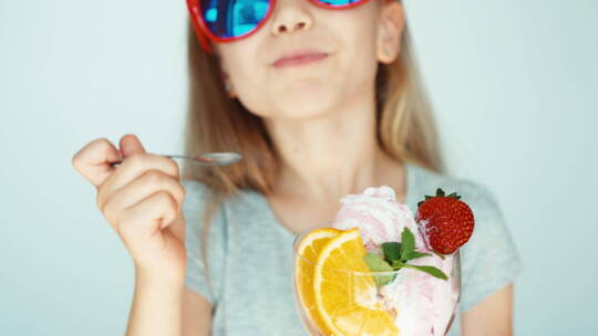 女孩戴着太阳镜吃冰淇淋