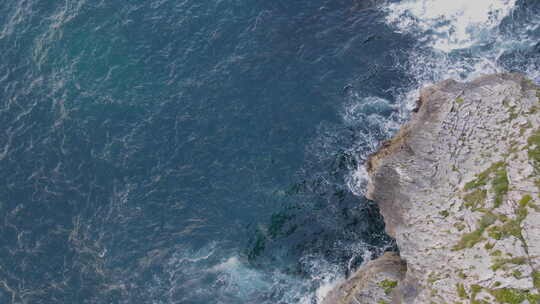 航拍海浪在岩石海岸线上拍打