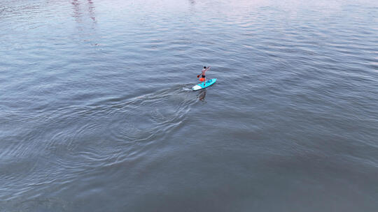 航拍长江中划船帆板运动健身的男士