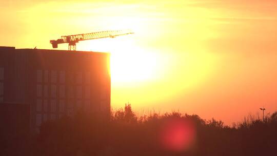 黄昏夕阳下工作的建筑吊塔视频素材模板下载