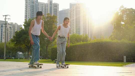 公园里结伴而行的滑板车男女青年