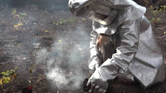 穿防火服的男子检查火山爆发的熔岩流