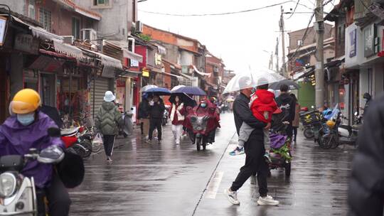 下雨天西街阴雨天街道上撑伞的路人行走视角视频素材模板下载