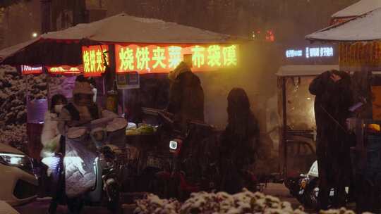 雪中城市夜晚街头小摊贩和雪中值守的警车