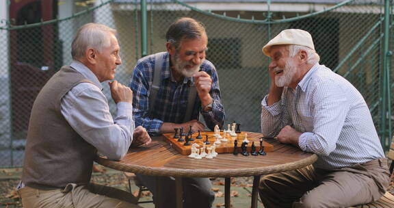 退休老人围着桌子下国际象棋  