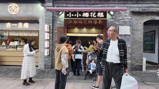 扬州江南梅花糕店前热闹的街道景象