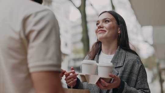 在城市街道接受外卖咖啡的妇女