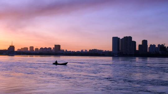 清晨日出一艘渔船在哈尔滨松花江逆流而上