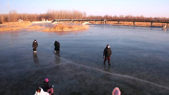 航拍冬季在结冰的河流冰面上滑冰玩耍的游人
