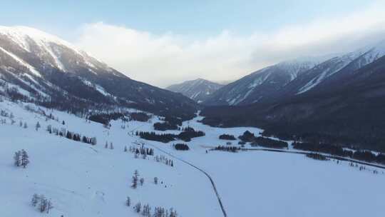 航拍新疆冬季喀纳斯湖雪景雪山森林冰河晨雾