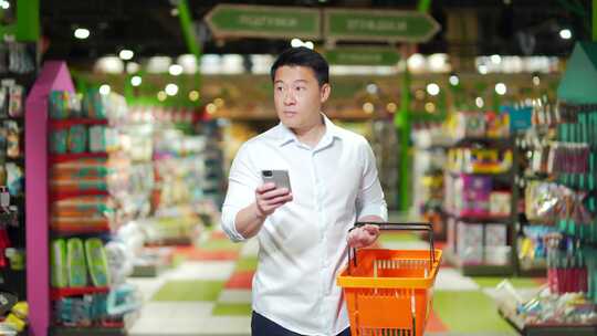 亚洲男性购物者拿着购物车在超市里走来走去视频素材模板下载