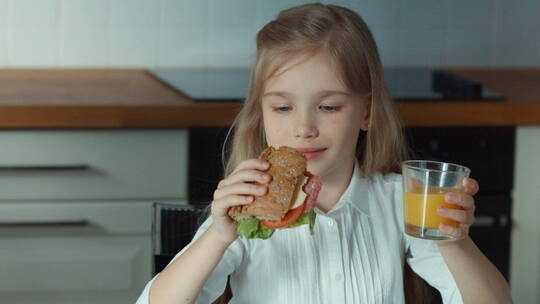 女孩开心的拿着三明治和一杯橙汁视频素材模板下载