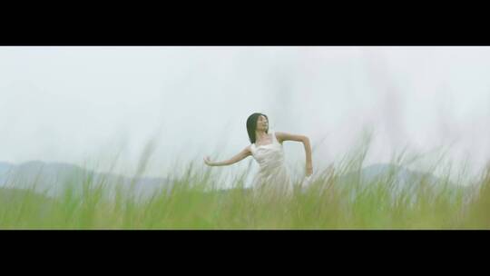 白色连衣裙女子在草地上旋转跳舞