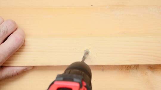 木匠用电钻在木板上钻孔