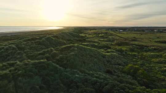 日出时沿海的田野、沙丘和海岸