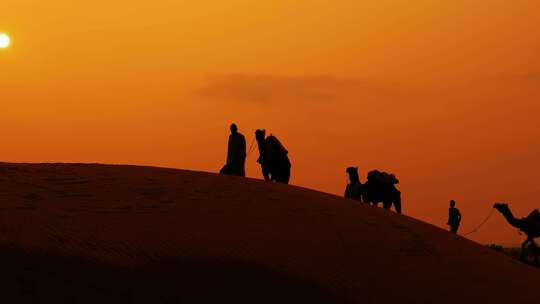 夕阳骆驼队伍在沙漠行走剪影-近景视频素材模板下载