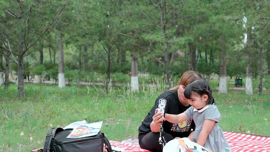 在公园草坪上玩耍的中国母女