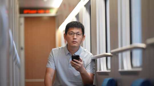 男子在卧铺火车过道上使用手机