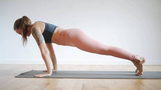 一个女人在瑜伽垫上做伸展