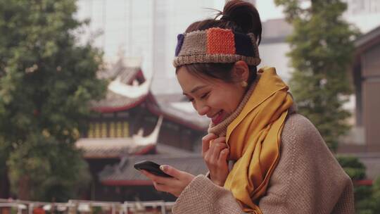 美女游客在成都大慈寺看手机发消息微笑