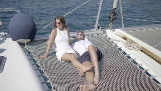 富有的夫妇在双体船上放松视频素材模板下载