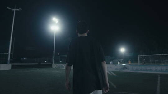 夜晚一个人走在空荡的足球场内视频素材模板下载