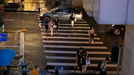 路上行人行走斑马线下雨过马路