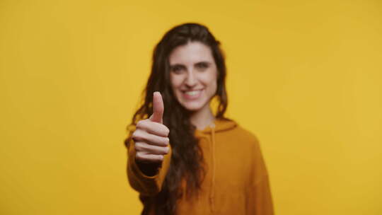 快乐的女人在黄色上竖起大拇指视频素材模板下载