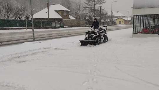 一个人用全地形车从人行道上除雪