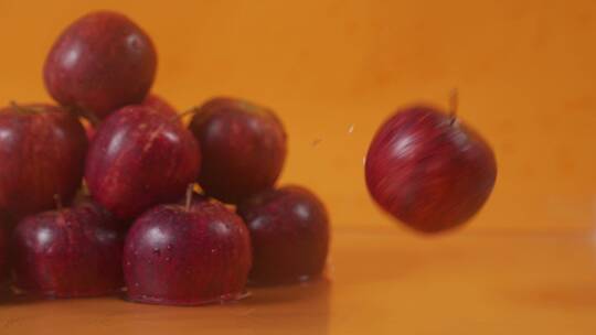 慢速红苹果水果旋转掉落在水面上