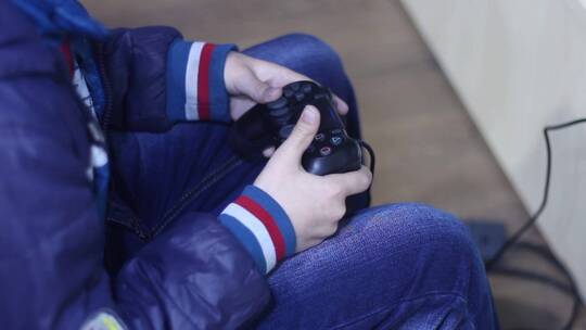 男孩在玩电子游戏机视频素材模板下载