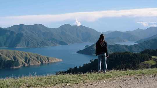 女人站着望着水和山