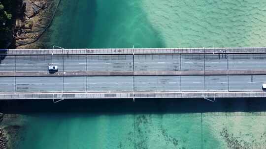 繁忙的沿海道路和人行天桥横跨清澈的海洋河口，允许人员和车辆