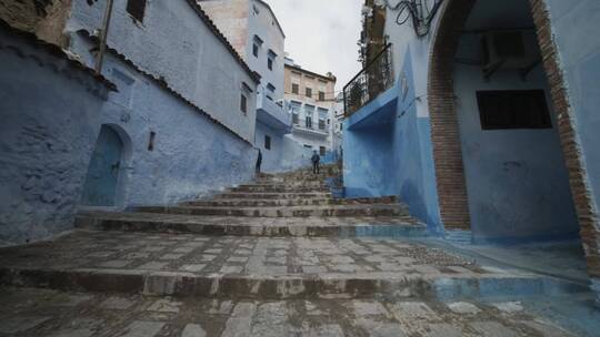 走上一条被漆成蓝色的古老胡同的台阶