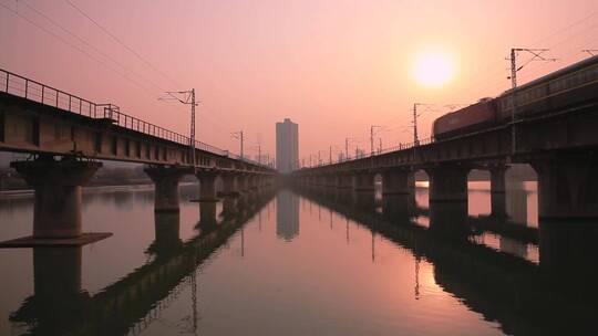 夕阳下在桥梁上行驰中的火车