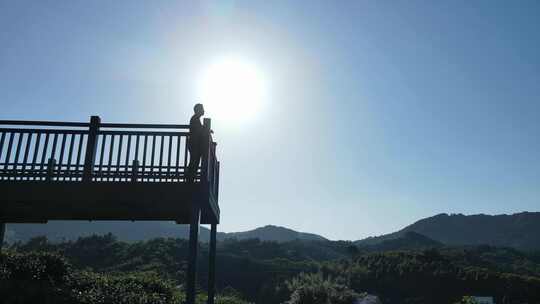 男子于观景台眺望远方山峦